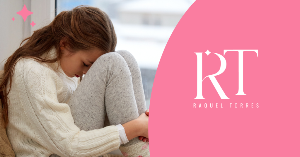 Una niña con la cabeza apoyada en sus rodillas, con una expresión de tristeza, soledad o malestar emocional.